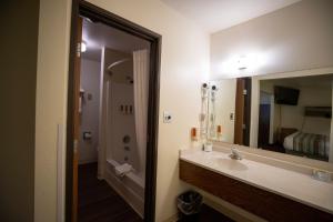 a bathroom with a sink and a large mirror at Mountain Vista Hotel in West Yellowstone