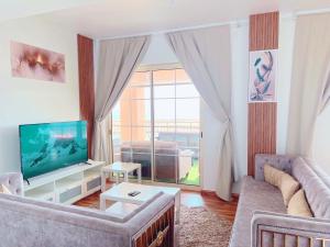 a living room with a couch and a television at رويال مارينا بانوراما ثلاث غرف Royal Beach family and businesses in King Abdullah Economic City