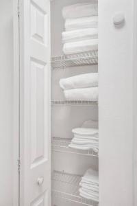 a closet with white towels sitting on shelves at Beachside Duplex off Flagler with FREE garage parking in New Smyrna Beach