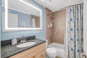 a bathroom with a sink and a toilet and a tub at Beachside Duplex off Flagler with FREE garage parking in New Smyrna Beach