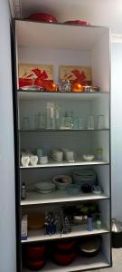 a shelf full of dishes and bowls and plates at Qunu Heritage Home - Mthatha in Mthatha
