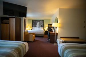 a hotel room with two beds and a television at Mountain Vista Hotel in West Yellowstone