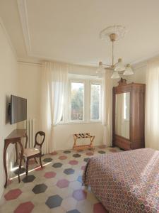 Villa Giulia BnB في فياريجيو: غرفة نوم بسرير وطاولة وكرسي