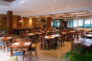 un restaurant avec des tables et des chaises en bois ainsi qu'un bar dans l'établissement Hotel Habitel Select, à Bogotá