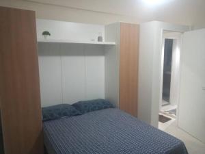 a bedroom with a bed in a room with a shelf at Apartamento ao lado do metro da Cinelândia e Consulado Americano in Rio de Janeiro
