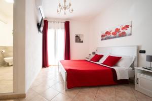 una camera con letto rosso e bianco con cuscini rossi di AbbaNive a Mamoiada