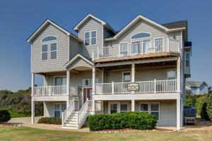 a large apartment building with balconies and bushes at Southern Paws in Southern Shores