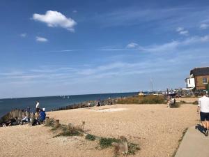 a group of people on a beach near the ocean at Whitstable Link in Whitstable