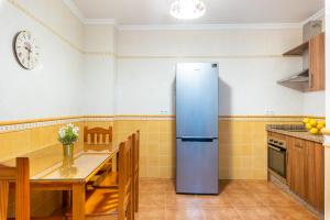a kitchen with a refrigerator and a table in it at CASA ANGELITA Caminito del Rey, Apartamento con cocina en el centro de Andalucía in Valle de Abdalagís +2 photos