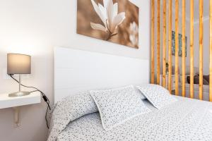 1 dormitorio con 1 cama y una foto en la pared en CASA ANGELITA Caminito del Rey, Apartamento con cocina en el centro de Andalucía, en Valle de Abdalajís