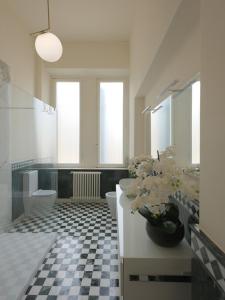 baño con 2 aseos y lavamanos con flores en Villa Giulia BnB, en Viareggio