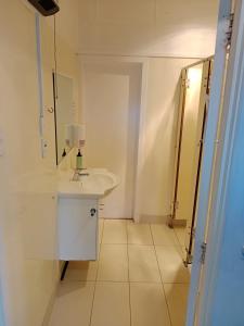 a white bathroom with a sink and a mirror at Lakeside Backpackers in Queenstown