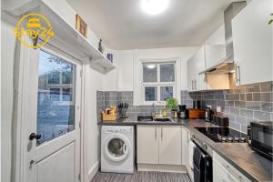 a kitchen with a washer and dryer in it at Alton Suite in Crewe