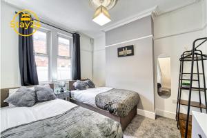 1 dormitorio con 2 camas y reloj en la pared en Alton Suite en Crewe
