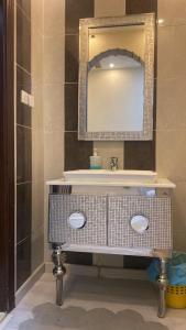 een badkamer met een wastafel en een spiegel bij Holiday apartment in Mekka