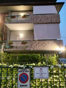 a building with a sign in front of a fence at Casa vacanza Orio al Serio Bergamo in Orio al Serio