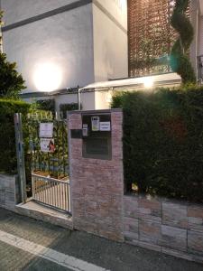 un muro di mattoni con cancello di fronte a un edificio di Casa vacanza Orio al Serio Bergamo a Orio al Serio