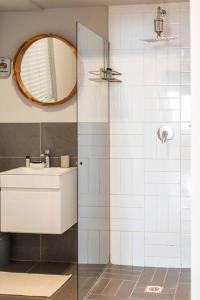 y baño con ducha, lavabo y espejo. en Two bedroom Apartment on kloof en Ciudad del Cabo
