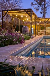 un pabellón con luces y flores junto a una piscina en Hotel Hoja de Parra en Santa Cruz
