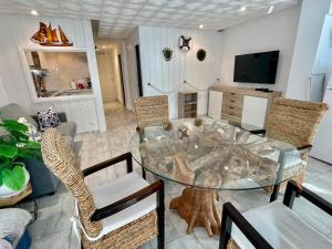 a dining room with a glass table and chairs at Magnifique appartement en front de mer, Caneylles in Roses
