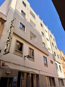 Ein hohes weißes Gebäude mit einem Schild drauf. in der Unterkunft Hotel Horizonte in Santa Cruz de Tenerife