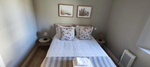 małą sypialnię z łóżkiem i 2 zdjęciami na ścianie w obiekcie La Casita de Sofia w mieście El Escorial