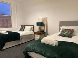 a bedroom with two beds and a window at Bridgewater Flat in Bridgwater