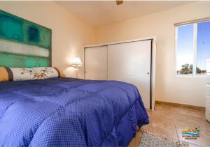 a bedroom with a blue bed and a large closet at Casa Desert Rose - Gated Community San Felipe Vacation Rental Home in Playa Hawaii