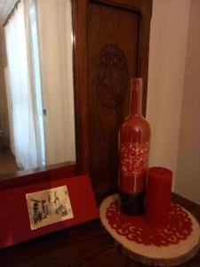 una bottiglia di vino seduta su un tavolo con una candela di Cantina Monpissan a Canale