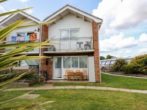 a house with a balcony with a table and chairs at 63 The Waterside Holiday Park in Lowestoft