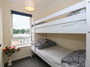 twee stapelbedden in een kamer met een raam bij 63 The Waterside Holiday Park in Lowestoft
