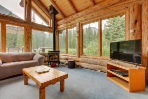 クック・シティにあるScenic Montana Cabin Rental about 1 Mi to Yellowstone!のテレビ、ソファ、テーブルのあるリビングルーム