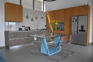 a kitchen with a glass table with chairs and a refrigerator at Stylish Villa - Skylodge in Tolo
