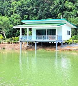 una casa al borde de un cuerpo de agua en บังกะโลบ้านสวนเอก Bungalow Baan Suan Aek, 