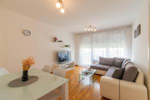 een woonkamer met een bank en een tafel bij Flexible SelfCheckIns 56 - Zagreb - Garage - Loggia - New in Zagreb