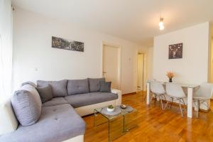 a living room with a couch and a table at Flexible SelfCheckIns 56 - Zagreb - Garage - Loggia - New in Zagreb