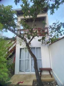a house with a tree in front of a window at Pousada Flor de Debora in Alto Paraíso de Goiás
