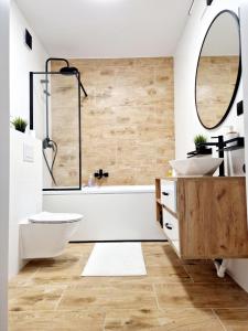 bagno con 2 lavandini, vasca e specchio di Comfortable flat with garden a Poznań