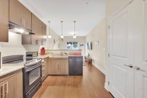 a kitchen with stainless steel appliances and wooden cabinets at Convenient - KING Bed Apartment - Heart of Plaza in Charlotte