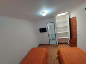 Habitación pequeña con 2 camas y espejo. en Residencial RO, en Copiapó