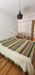 ein Bett in einem Schlafzimmer mit einer Decke drauf in der Unterkunft Casa en Raco in San Miguel de Tucumán
