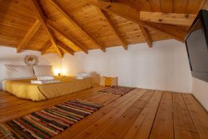 a bedroom with a bed and a flat screen tv at Pomogna house in Pemónia