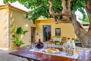 una mesa de madera con botellas de vino y copas. en Pomogna house en Pemónia