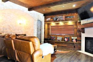a living room with a leather couch and a fireplace at The Rustic Inn - Family friendly, Close to Fiesta Texas, SeaWorld, Riverwalk and more in Dominion