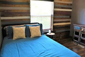 a bedroom with a bed with blue sheets and a window at The Rustic Inn - Family friendly, Close to Fiesta Texas, SeaWorld, Riverwalk and more in Dominion
