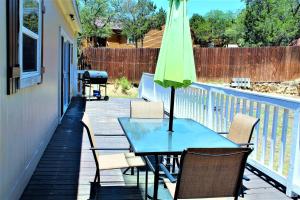 a table and chairs with a green umbrella on a patio at The Rustic Inn - Family friendly, Close to Fiesta Texas, SeaWorld, Riverwalk and more in Dominion