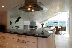 a kitchen with a counter top and a dining room at Villa Arboretet - Seaside villa with private pool & infrared sauna in the heart of Arboretet, Bergen in Bergen