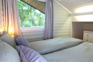 sypialnia z łóżkiem z oknem w obiekcie Villa Arboretet - Seaside villa with private pool & infrared sauna in the heart of Arboretet, Bergen w Bergen