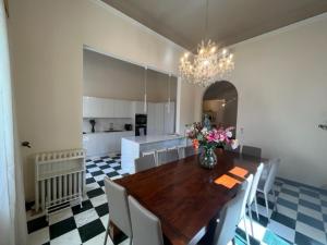 a dining room with a table and a vase of flowers at Villa Giulia BnB in Viareggio