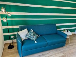 un divano blu in una stanza a strisce verdi e bianche di La Casa di Chiara a La Spezia